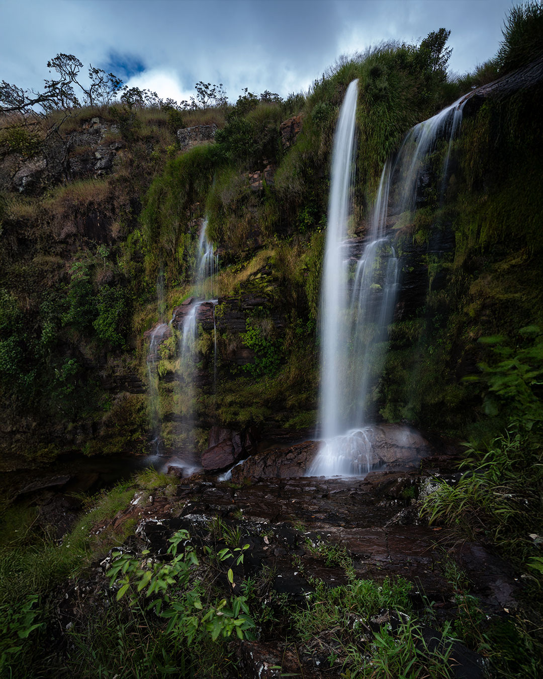 A trilha da Cachoeira do Jota, na Serra da Canastra, acessa o poço principal na parte de baixo, e depois uma cachoeirinha na parte de cima, que eu não achei tão fotogência. Mas no meio desse caminho, vimos que tinha uma queda intermediária, que era bem maior e promissora para fotografia!
.
Não sei se tem uma trilha bem demarcada para ela, mas seguimos algumas partes que o mato estava um pouco mais pisado, e com um pouco de empenho finalmente chegamos nessas quedas!
.
Aqui o acesso é mais complicado, a pedra parecia um sabão, e qualquer descuido poderia ocasionar num acidente mais grave. Portanto, ficamos um pouco mais pra trás, onde ainda tinha um pouco de mato para dar mais aderência nos calçados. E de lá mesmo fiz essa foto, que na minha opinião, foi a que mais gostei dessa pequena cachoeira em São João Batista.
.
.
#serradacanastra #saojoaobatista #saoroquedeminas #mg #cachoeiradojota @saojoaodacanastra